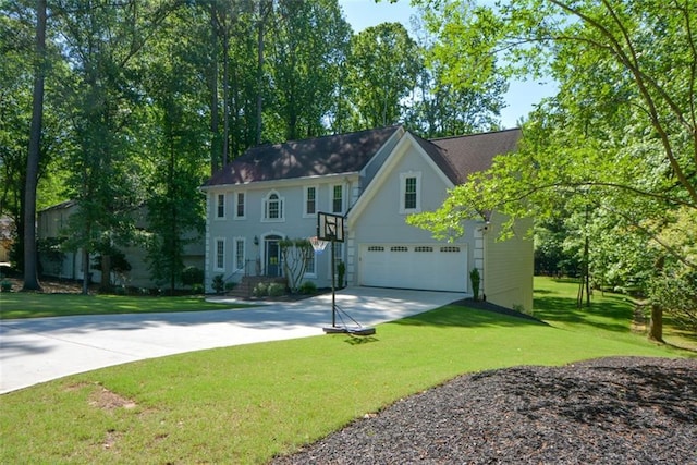 colonial inspired home featuring driveway, a front lawn, and a garage