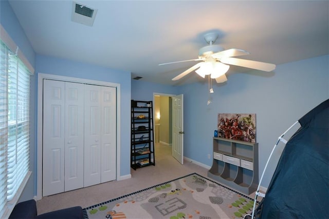 carpeted bedroom featuring baseboards, a closet, and ceiling fan