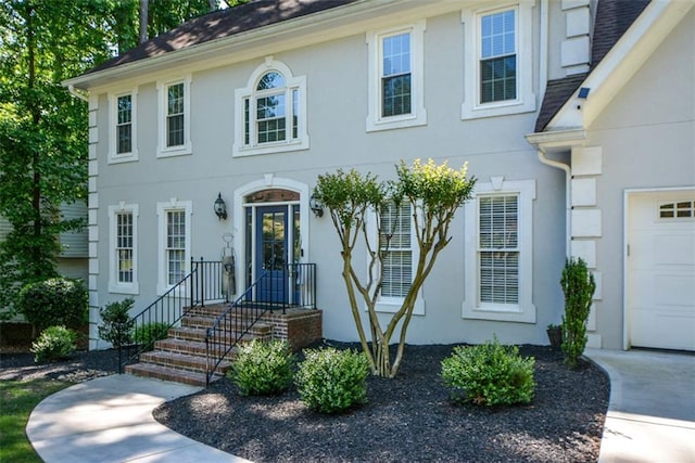 view of front of home featuring stucco siding and roof with shingles