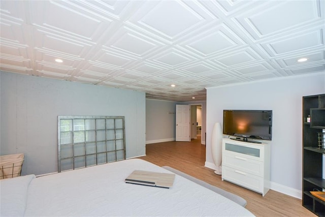 bedroom featuring light wood-style floors, an ornate ceiling, recessed lighting, and baseboards