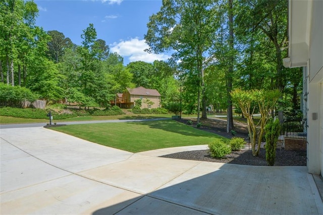 view of home's community with a lawn and a patio area