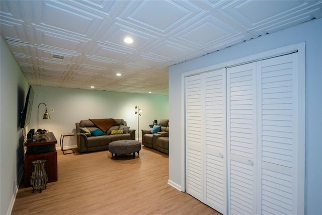 living room with baseboards, wood finished floors, recessed lighting, and an ornate ceiling
