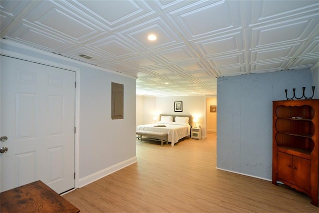 bedroom with an ornate ceiling, baseboards, and light wood finished floors