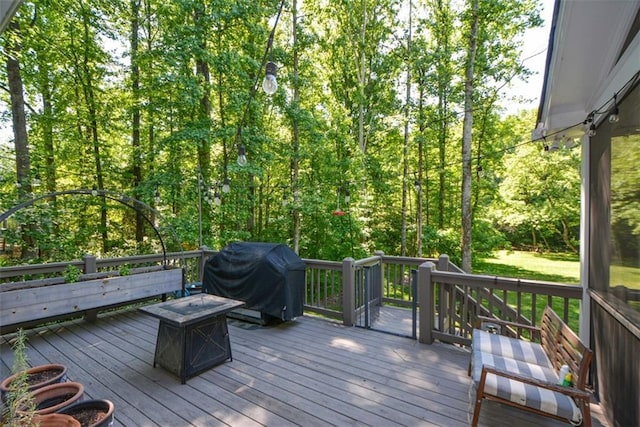 deck with a grill and a fire pit