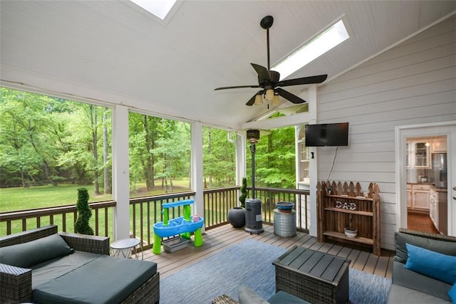 wooden deck with a ceiling fan, a lawn, and outdoor lounge area