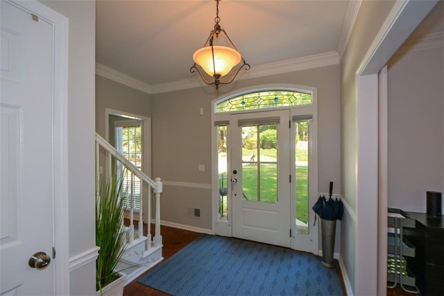 foyer entrance with stairway, ornamental molding, and baseboards