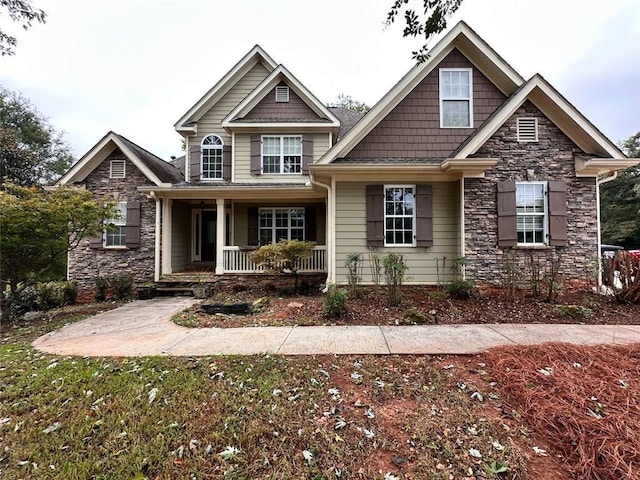 craftsman inspired home featuring covered porch and stone siding