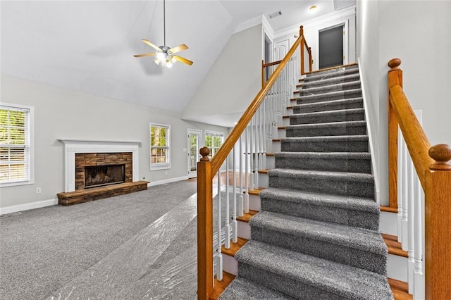 stairway with high vaulted ceiling, carpet flooring, a fireplace, and baseboards