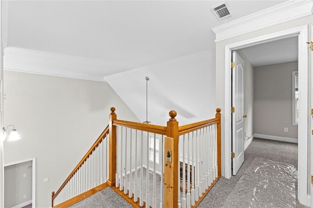 hallway featuring carpet floors, visible vents, an upstairs landing, and baseboards