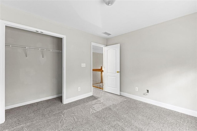 unfurnished bedroom with a closet, baseboards, visible vents, and carpet flooring