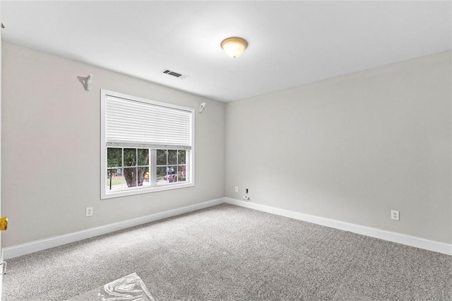 empty room featuring baseboards, visible vents, and carpet flooring