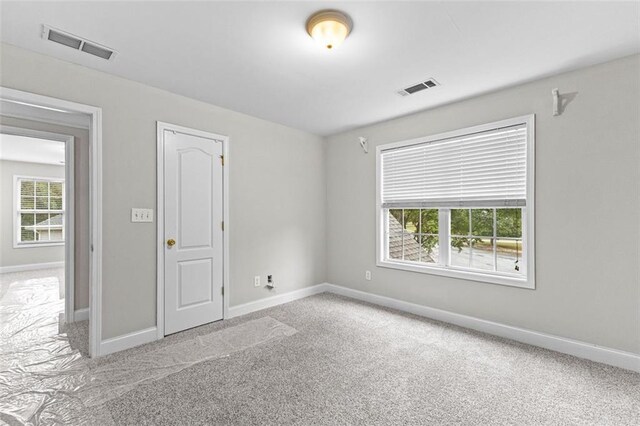 carpeted empty room with baseboards and visible vents