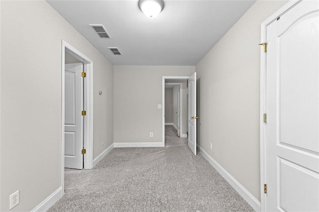 unfurnished bedroom with carpet floors, baseboards, and visible vents