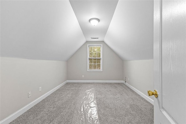 additional living space with vaulted ceiling, carpet floors, visible vents, and baseboards