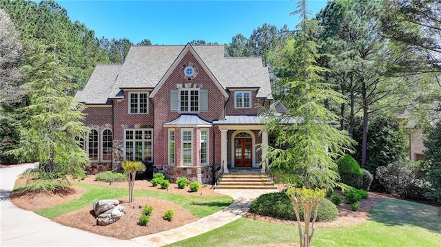 4505 Whitestone Way, Suwanee, GA 30024 - view of front facade with a standing seam roof, metal roof, a front yard, stone siding, and french doors