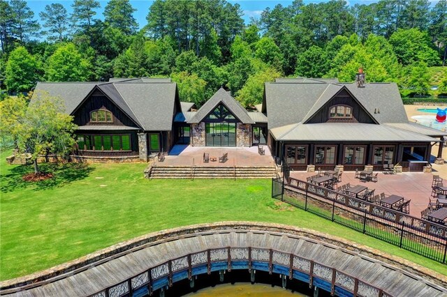4505 Whitestone Way, Suwanee, GA 30024 - back of house featuring a patio, a fenced backyard, stone siding, and a lawn