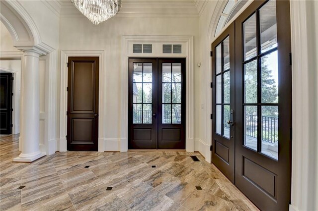 4505 Whitestone Way, Suwanee, GA 30024 - entrance foyer featuring ornate columns, french doors, an inviting chandelier, and crown molding