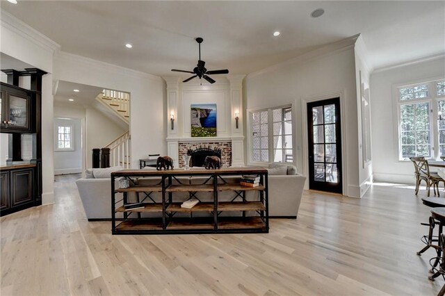 4505 Whitestone Way, Suwanee, GA 30024 - living room with stairway, light wood finished floors, a brick fireplace, and crown molding