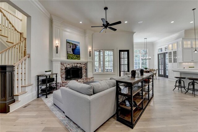 4505 Whitestone Way, Suwanee, GA 30024 - living area featuring ceiling fan with notable chandelier, a fireplace, recessed lighting, stairs, and light wood finished floors