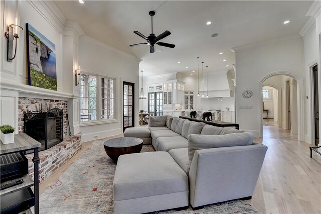 4505 Whitestone Way, Suwanee, GA 30024 - living room with baseboards, a fireplace, crown molding, a ceiling fan, and arched walkways