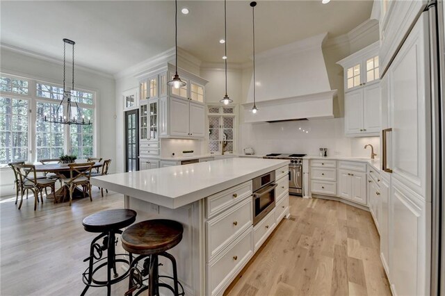 4505 Whitestone Way, Suwanee, GA 30024 - kitchen featuring custom exhaust hood, ornamental molding, appliances with stainless steel finishes, light wood-style floors, and a kitchen island