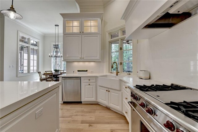 4505 Whitestone Way, Suwanee, GA 30024 - kitchen with range hood, decorative light fixtures, a sink, appliances with stainless steel finishes, and light wood finished floors