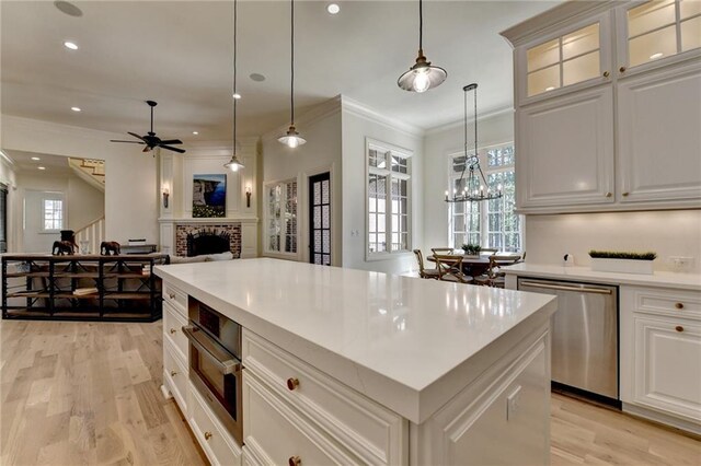 4505 Whitestone Way, Suwanee, GA 30024 - kitchen with a fireplace, light wood-type flooring, ornamental molding, appliances with stainless steel finishes, and open floor plan