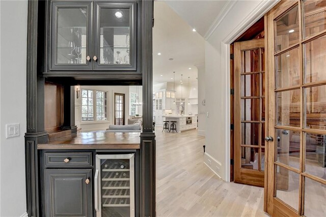 4505 Whitestone Way, Suwanee, GA 30024 - bar with baseboards, ornamental molding, light wood-style flooring, french doors, and beverage cooler
