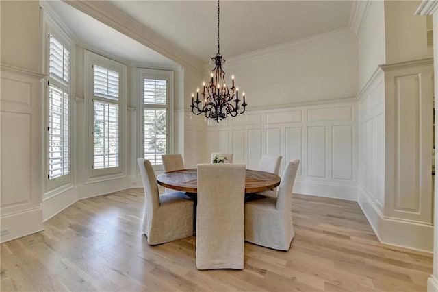 4505 Whitestone Way, Suwanee, GA 30024 - dining area featuring a decorative wall, ornamental molding, light wood-style flooring, and a notable chandelier