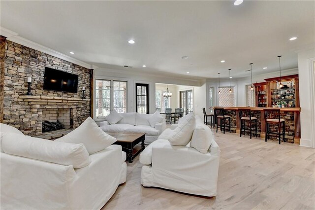 4505 Whitestone Way, Suwanee, GA 30024 - living area with ornamental molding, a stone fireplace, recessed lighting, a chandelier, and a bar