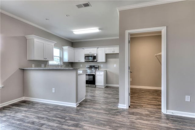 kitchen featuring stainless steel appliances, visible vents, white cabinetry, ornamental molding, and dark wood-style floors