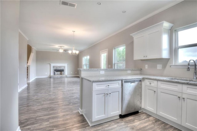 kitchen featuring visible vents, stainless steel dishwasher, ornamental molding, white cabinets, and a sink