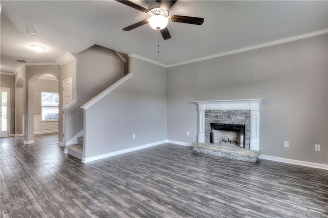 unfurnished living room with a stone fireplace, wood finished floors, baseboards, stairs, and ornamental molding