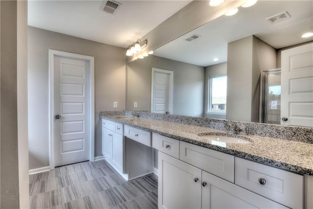 bathroom featuring visible vents, a sink, and double vanity