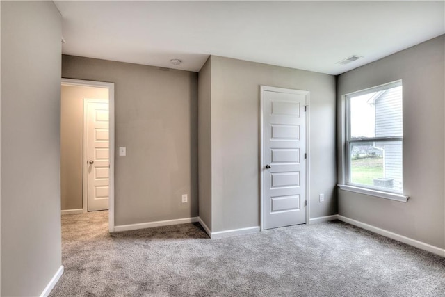 unfurnished bedroom featuring carpet flooring, visible vents, and baseboards