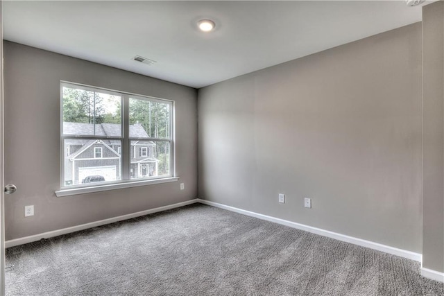 carpeted empty room featuring visible vents and baseboards