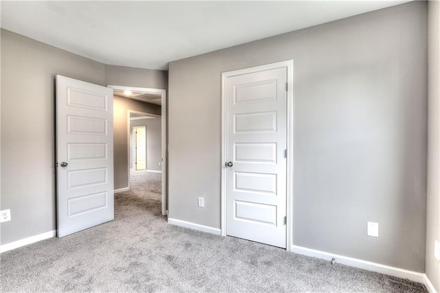 unfurnished bedroom featuring carpet floors and baseboards