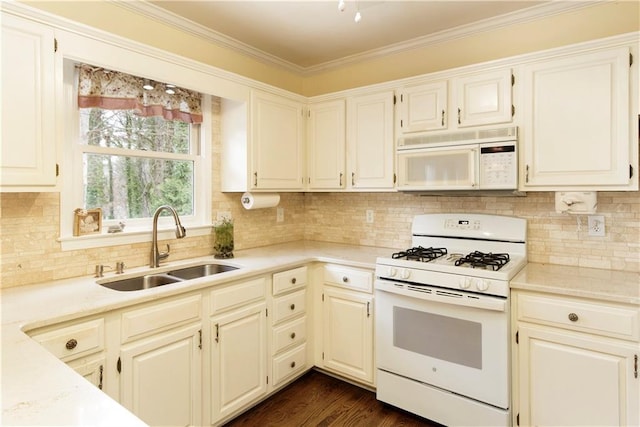 kitchen featuring tasteful backsplash, ornamental molding, dark wood-style floors, white appliances, and a sink