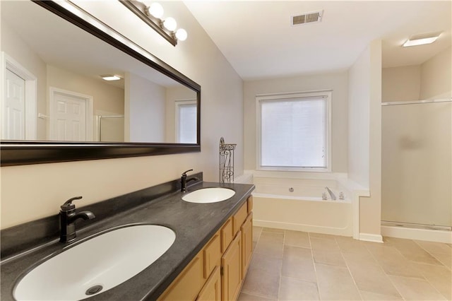 bathroom featuring a garden tub, a stall shower, visible vents, and a sink