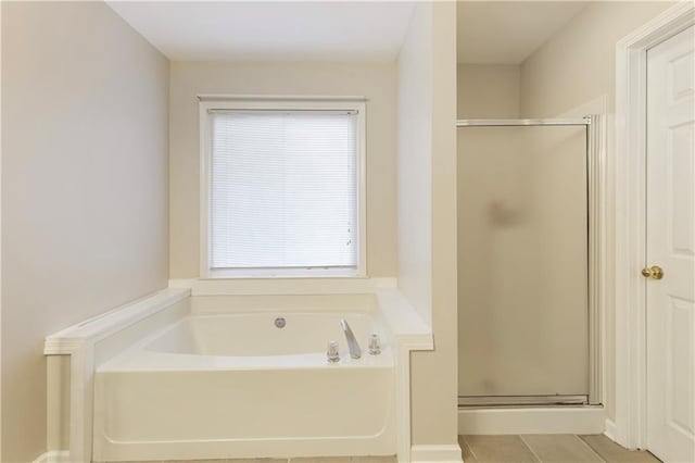 full bathroom featuring tile patterned floors, a bath, and a shower stall