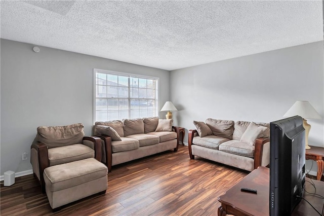 living room with dark hardwood / wood-style flooring and a textured ceiling