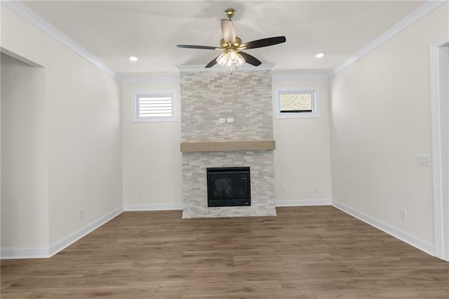 unfurnished living room with a fireplace, ornamental molding, ceiling fan, wood finished floors, and baseboards