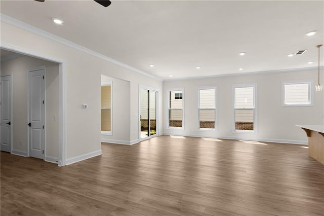 unfurnished living room featuring baseboards, recessed lighting, wood finished floors, and crown molding