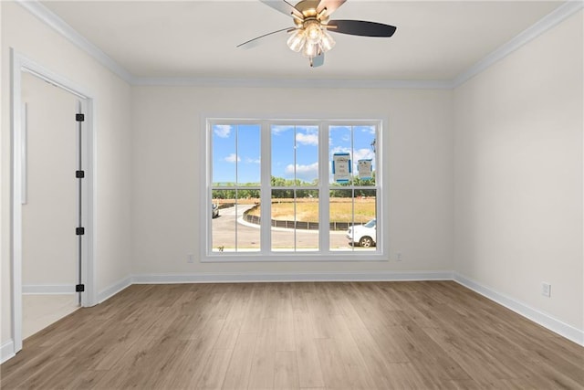 spare room featuring light wood-style floors, baseboards, and ornamental molding