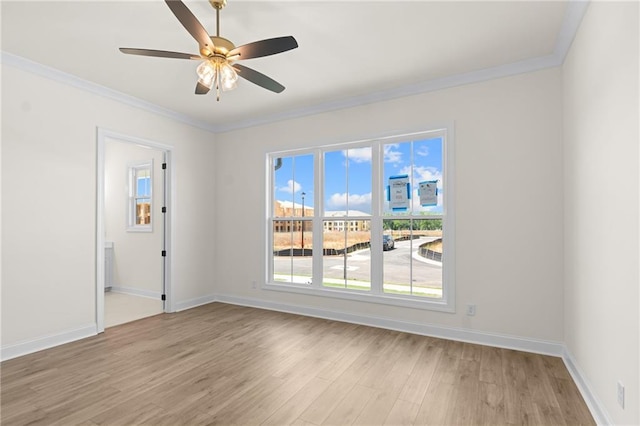 spare room featuring ornamental molding, light wood-style floors, and baseboards