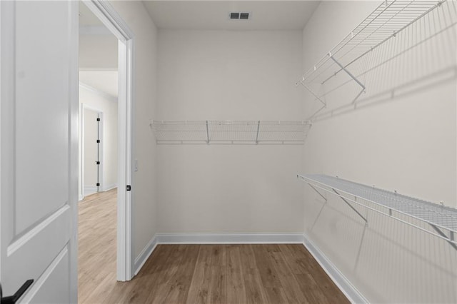 spacious closet with wood finished floors and visible vents