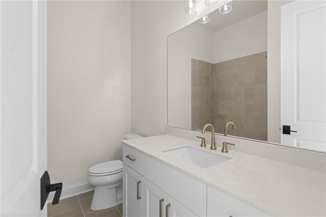 bathroom featuring toilet, tile patterned flooring, vanity, and baseboards