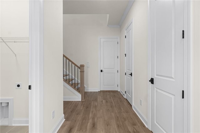 corridor with stairway, baseboards, and wood finished floors