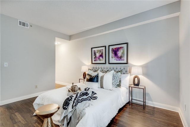 bedroom with visible vents, baseboards, and wood finished floors