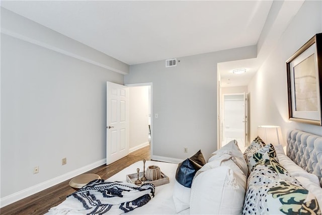 bedroom with visible vents, baseboards, and wood finished floors